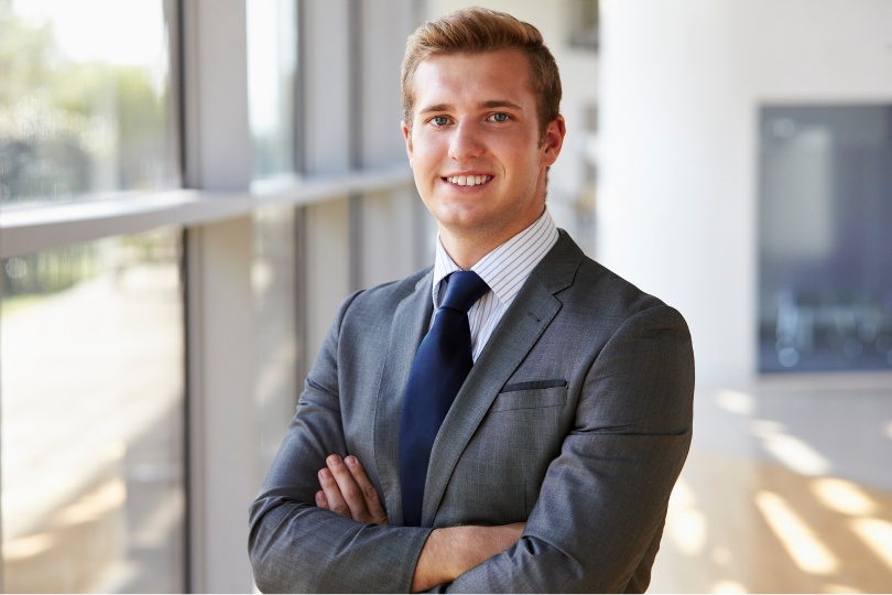 Confident business professional standing in a modern office environment, symbolizing expertise in Competitor Analysis Strategy Services.